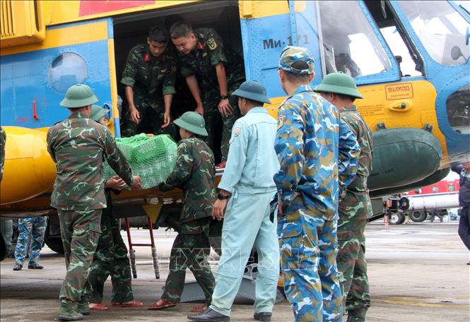 Lực lượng cứu trợ vận chuyển mì tôm, lương khô, nước.... lên trực thăng để chuyển đến các xã phía Tây Nghệ An đang bị cô lập. Ảnh: Văn Tý-TTXVN