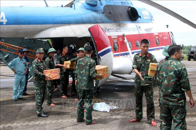Lực lượng cứu trợ vận chuyển mì tôm, lương khô, nước lên trực thăng để chuyển đến các xã đang bị cô lập. Ảnh: Văn Tý-TTXVN