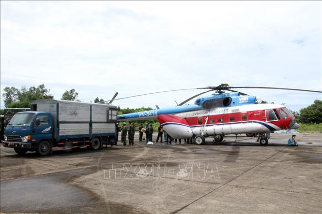 Lực lượng cứu trợ vận chuyển mì tôm, lương khô, nước.... lên trực thăng để chuyển đến các xã phía Tây Nghệ An đang bị cô lập. Ảnh: Văn Tý-TTXVN