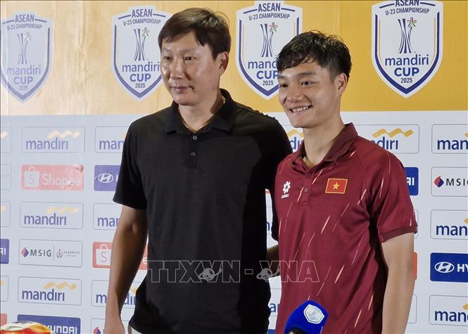 HLV trưởng U23 Việt Nam Kim Sang Sik chụp ảnh lưu niệm cùng cầu thủ Nguyễn Xuân Bắc. Ảnh: Minh Thái - Phóng viên TTXVN tại Indonesia