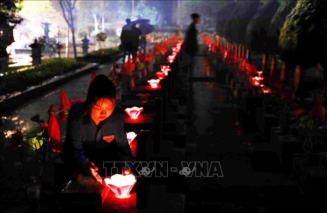 Đoàn viên thanh niên cùng các cựu chiến binh thắp nến tri ân các anh hùng liệt sĩ. Ảnh: Quý Trung – TTXVN