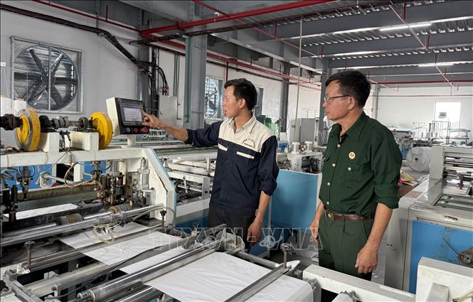 Ông Trịnh Văn Nghiên (bên phải) kiểm tra công nhân làm việc. Ảnh: Nguyễn Lành - TTXVN 