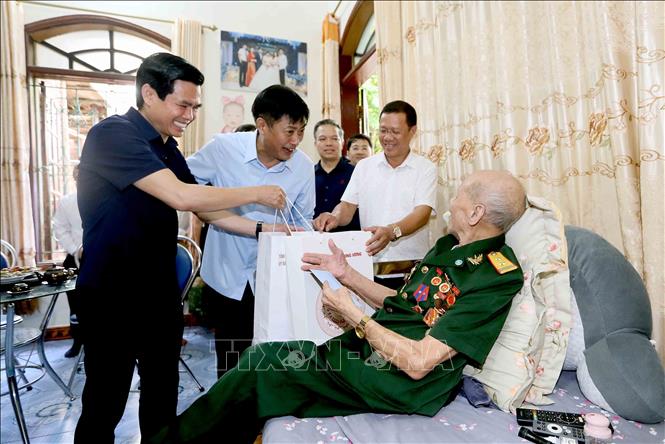 Ủy viên Trung ương Đảng, Phó trưởng Ban Nội chính Trung ương Nguyễn Hữu Đông và Bí thư Tỉnh ủy Sơn La Hoàng Quốc Khánh thăm, tặng quà lão thành cách mạng Hà Văn Thu ở bản Giảng Lắc, phường Tô Hiệu. Ảnh: Quang Quyết - TTXVN