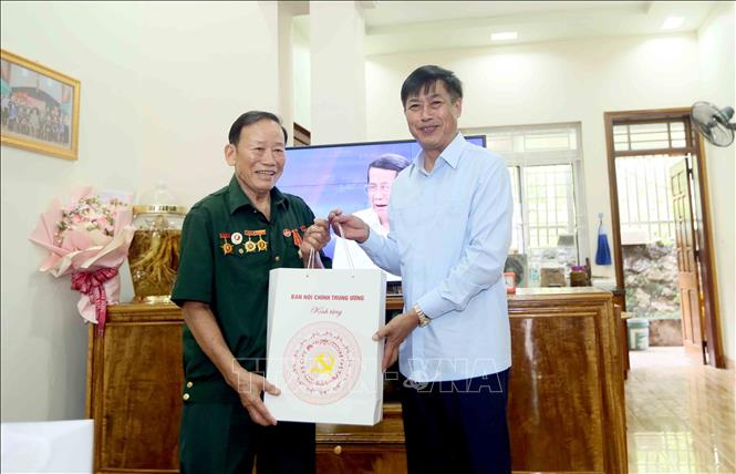 Ủy viên Trung ương Đảng, Phó trưởng Ban Nội chính Trung ương Nguyễn Hữu Đông thăm, tặng quà thương binh Lò Văn Song, tổ 10 Chiềng Lề, phường Tô Hiệu. Ảnh: Quang Quyết - TTXVN
