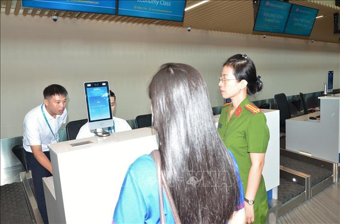 Công an hướng dẫn hành khách thực hiện thủ tục sinh trắc học tại Cảng hàng không quốc tế Tân Sơn Nhất. Ảnh: Linh Sơn – TTXVN