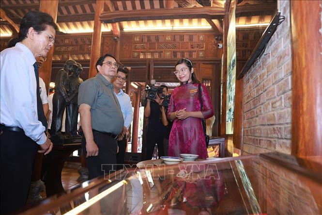Thủ tướng Phạm Minh Chính xem trưng bày hình ảnh và hiện vật và tư liệu về Đại tướng Nguyễn Chí Thanh ở thành phố Huế. Ảnh: Dương Giang-TTXVN 
