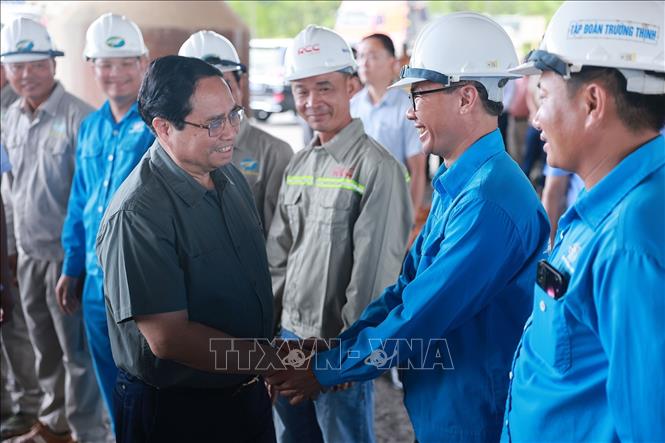 Thủ tướng Phạm Minh Chính với công nhân thi công Dự án đầu tư xây dựng cao tốc Bắc - Nam phía Đông đoạn Vạn Ninh - Cam Lộ. Ảnh: Dương Giang-TTXVN 
