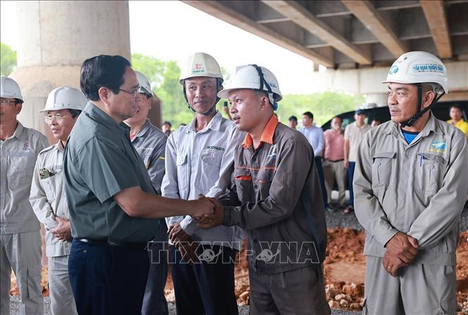 Thủ tướng Phạm Minh Chính với công nhân thi công Dự án đầu tư xây dựng cao tốc Bắc - Nam phía Đông đoạn Vạn Ninh - Cam Lộ. Ảnh: Dương Giang-TTXVN 

