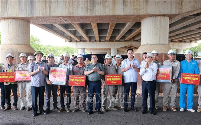 Thủ tướng Phạm Minh Chính tặng quà cho công nhân thi công Dự án đầu tư xây dựng cao tốc Bắc - Nam phía Đông đoạn Vạn Ninh - Cam Lộ. Ảnh: Dương Giang-TTXVN 
