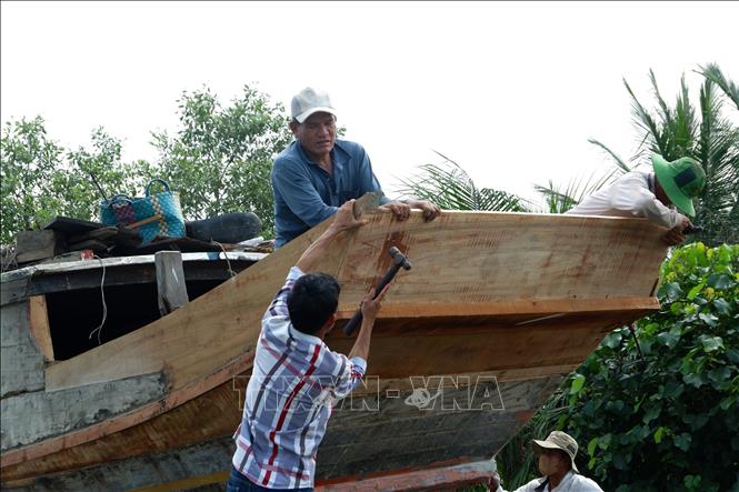 Những người thợ làng đóng ghe xã Đông Thạnh, huyện Cần Giuộc xưa sửa chữa ghe. Ảnh: Đức Hạnh - TTXVN