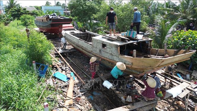 Những chiếc ghe đang được những người thợ làng đóng ghe xã Đông Thạnh, huyện Cần Giuộc xưa sửa chữa. Ảnh: Thành Phương - TTXVN
