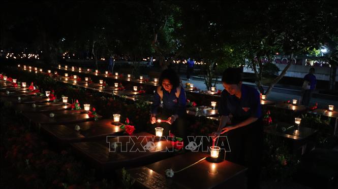 Đoàn viên, thanh niên thắp nến tri ân lên phần mộ liệt sĩ. Ảnh: Hồng Thái - TTXVN