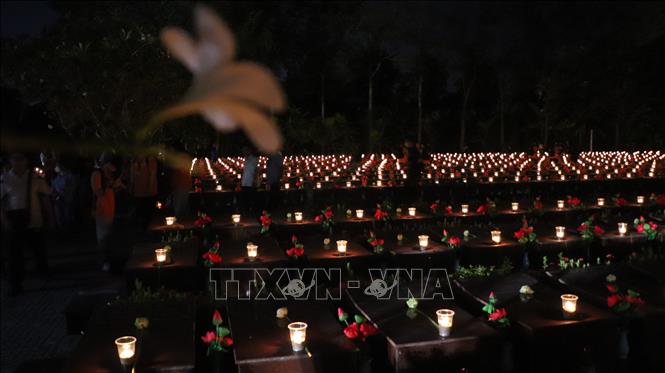 Đoàn viên, thanh niên thắp nến tri ân lên phần mộ liệt sĩ. Ảnh: Hồng Thái - TTXVN