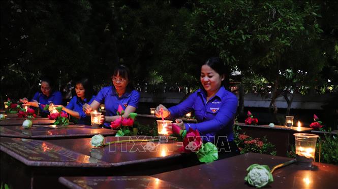 Đoàn viên, thanh niên thắp nến tri ân lên phần mộ liệt sĩ. Ảnh: Hồng Thái - TTXVN