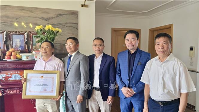 Tham tán Công xứ Chu Tuấn Đức (đứng giữa), Chủ tịch Hội CCB Việt Nam tại CHLB Đức trao giấy khen, tri ân công lao của gia đình ông Lê Đình Bính có người thân là liệt sĩ. Ảnh: Phương Hoa - PV TTXVN tại Đức