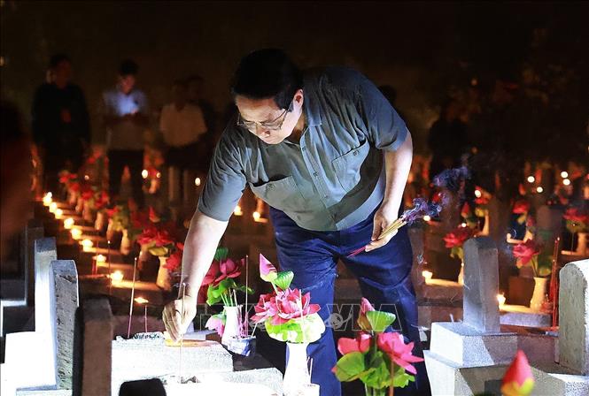 Prime Minister Pham Minh Chinh lights candles to commemorate war soldiersat the ceremony. VNA Photo: Dương Giang