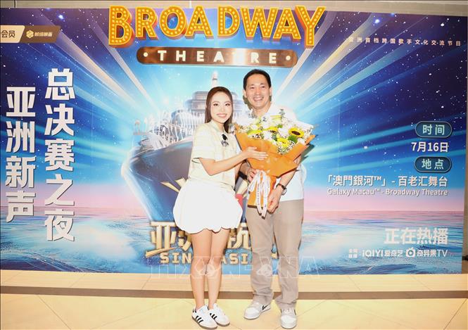 Chủ tịch Hiệp hội người Việt tại Macau Dương Trung Đức chúc mừng ca sĩ Phương Mỹ Chi. Ảnh: Xuân Vịnh - Phóng viên TTXVN từ Macau (Trung Quốc) 
