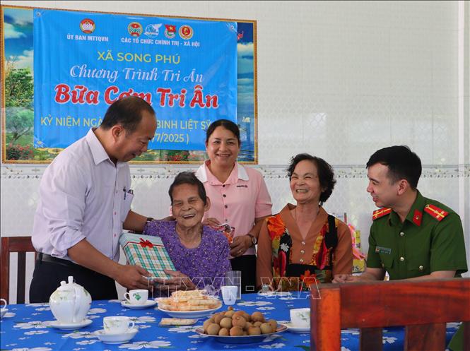 Đại diện Mặt trận Tổ quốc Việt Nam xã Song Phú, tỉnh Vĩnh Long tặng quà cho Bà Mẹ Việt Nam anh hùng Nguyễn Thị Bảy nhân dịp 27/7. Ảnh: Lê Thúy Hằng – TTXVN. 
