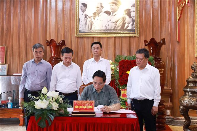 Thủ tướng Phạm Minh Chính viết lưu bút khi đến dâng hương tưởng niệm tại Đền thờ Bác Hồ và các Anh hùng liệt sĩ tỉnh Quảng Trị. Ảnh: Dương Giang-TTXVN 
