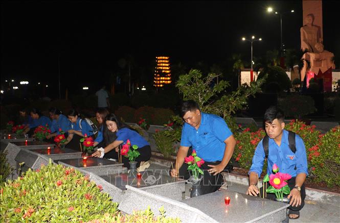 Đoàn viên thắp nến tri ân tại Nghĩa trang liệt sĩ tỉnh Vĩnh Long tối 26/7. Ảnh: Lê Thúy Hằng – TTXVN. 
