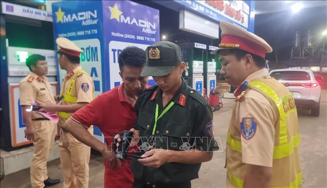 Lực lượng Cảnh sát giao thông trạm Đồng Phú kiểm tra hình ảnh, xử lý xe khách vi phạm giao thông. Ảnh: Đậu Tất Thành – TTXVN
