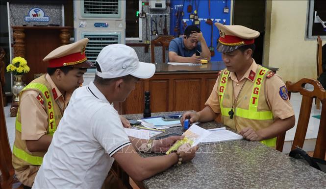 Lực lượng Cảnh sát giao thông trạm Đồng Phú lập biên bản, xử lý xe khách vi phạm giao thông. Ảnh: Đậu Tất Thành – TTXVN