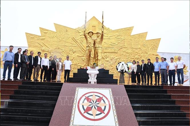 Các đại biểu chụp ảnh chung tại chân Tượng đài Liên minh chiến đấu Lào – Việt Nam ở huyện Paksong, tỉnh Champasak.  Ảnh: TTXVN phát