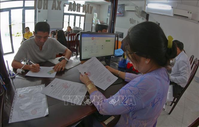 Người dân làm thủ tục hành chính tại Trung tâm phục vụ hành chính công xã Hỏa Lựu, thành phố Cần Thơ. Ảnh: Duy Khương - TTXVN 