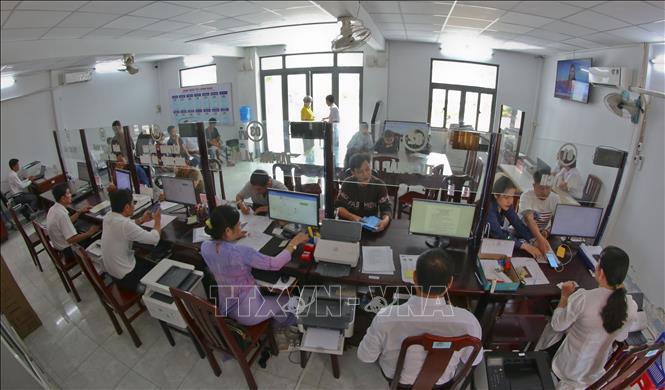 Người dân làm thủ tục hành chính tại Trung tâm phục vụ hành chính công xã Hỏa Tiến, thành phố Cần Thơ. Ảnh: Duy Khương - TTXVN 