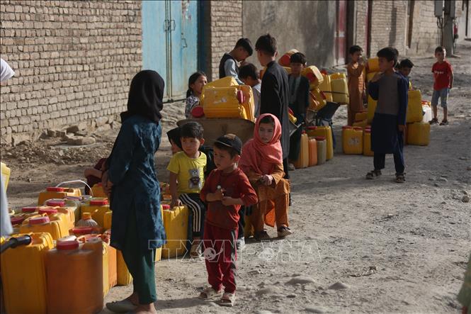 Các em nhỏ xếp hàng chờ lấy nước sinh hoạt tại vòi nước công cộng ở Kabul, Afghanistan. Ảnh: THX/TTXVN