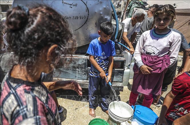 Các em nhỏ lấy nước sinh hoạt tại vòi nước công cộng ở Gaza. Ảnh: THX/TTXVN