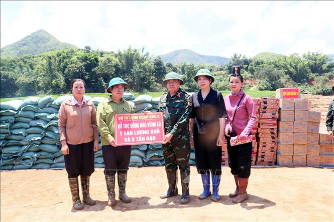 Trung tướng Phạm Đức Duyên, Chính ủy Quân Khu 2, trao biểu trưng hỗ trợ 1 tấn lương khô và 5 tấn gạo cho lãnh đạo xã Chiềng Sơ để cung ứng đến đồng bào vùng lũ. Ảnh: Quang Quyết - TTXVN