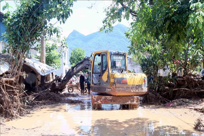 Máy xúc được huy động để nhanh chóng khắc phục hậu quả của lũ ống, lũ quét tại xã Chiềng Sơ. Ảnh: Quang Quyết - TTXVN