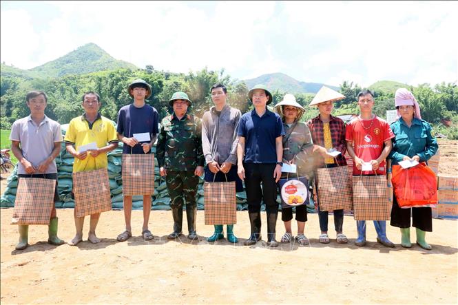 Bí thư Tỉnh ủy Sơn La Hoàng Quốc Khánh và Trung tướng Phạm Đức Duyên, Chính ủy Quân Khu 2, tặng quà cho các hộ dân bị mất nhà hoàn toàn tại xã Chiềng Sơ. Ảnh: Quang Quyết - TTXVN
