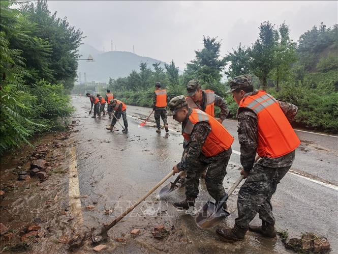 Cảnh sát dọn dẹp đất đá trên một đoạn đường sau mưa lũ tại Bắc Kinh, Trung Quốc ngày 27/7/2025. Ảnh: THX/TTXVN
