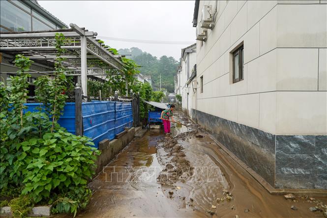 Người dân dọn bùn đất sau mưa lũ tại quận Mật Vân, Bắc Kinh, Trung Quốc. Ảnh: THX/TTXVN
