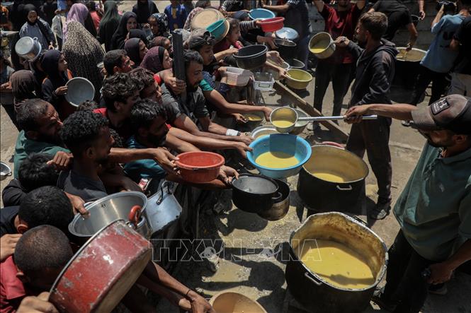 Người dân Palestine nhận thực phẩm cứu trợ tại Gaza. Ảnh: THX/TTXVN