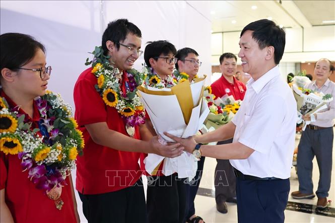 Đại diện Bộ Giáo dục và Đào tạo tặng hoa, chúc mừng đoàn. Ảnh: Thanh Tùng - TTXVN