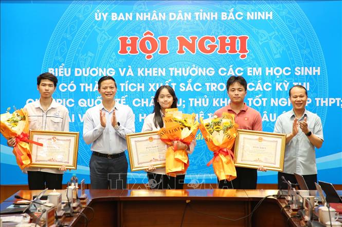 Chủ tịch UBND tỉnh Bắc Ninh Vương Quốc Tuấn (thứ 2 từ trái sang) trao Bằng khen cho 3 học sinh đoạt huy chương tại các kỳ thi Olympic quốc tế. Ảnh: Thái Hùng- TTXVN