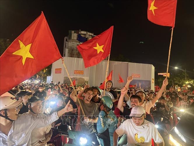 Người dân mang theo cờ Tổ quốc diễu hành trên các tuyến phố Hà Nội để mừng chiến thắng. Ảnh: An Đăng - TTXVN