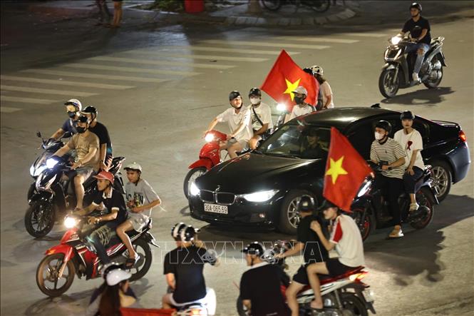 Người dân mang theo cờ Tổ quốc diễu hành trên các tuyến phố Hà Nội để mừng chiến thắng. Ảnh: Thanh Tùng - TTXVN
