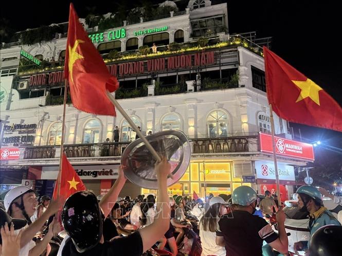 Người dân mang theo cờ Tổ quốc tập trung về khu vực Quảng trường Đông Kinh Nghĩa Thục để mừng chiến thắng. Ảnh: An Đăng - TTXVN