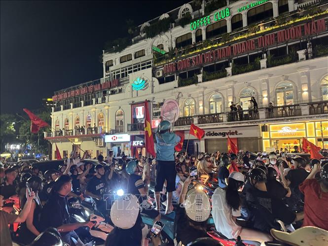 Người dân mang theo cờ Tổ quốc tập trung về khu vực Quảng trường Đông Kinh Nghĩa Thục để mừng chiến thắng. Ảnh: Minh Quyết - TTXVN