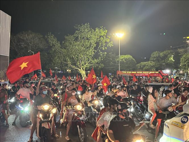 Người dân mang theo cờ Tổ quốc diễu hành trên các tuyến phố Hà Nội để mừng chiến thắng. Ảnh: Minh Quyết - TTXVN