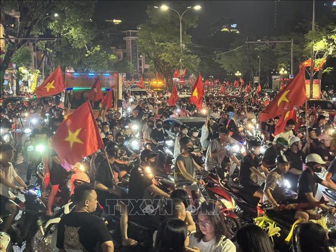 Người dân mang theo cờ Tổ quốc diễu hành trên các tuyến phố Hà Nội để mừng chiến thắng. Ảnh: Minh Quyết - TTXVN