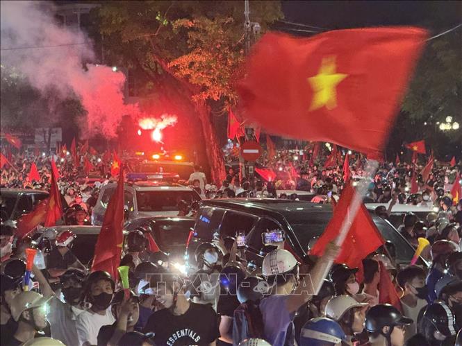 Người dân mang theo cờ Tổ quốc diễu hành trên các tuyến phố Hà Nội để mừng chiến thắng. Ảnh: Minh Quyết - TTXVN