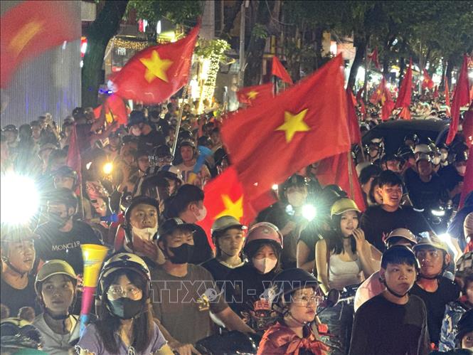 Người dân mang theo cờ Tổ quốc diễu hành trên các tuyến phố Hà Nội để mừng chiến thắng. Ảnh: Minh Quyết - TTXVN