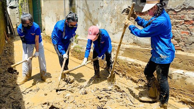 Lực lượng đoàn viên thanh niên xã Nga My hỗ trợ, giúp đỡ người dân xã Tương Dương dọn dẹp vệ sinh nhà cửa sau lũ. Ảnh: TTXVN phát