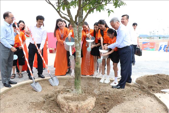 Phó Thủ tướng Thường trực Nguyễn Hòa Bình cùng các học sinh trồng cây trong khuôn viên Tổ hợp giáo dục FPT Huế. Ảnh: Mai Trang - TTXVN