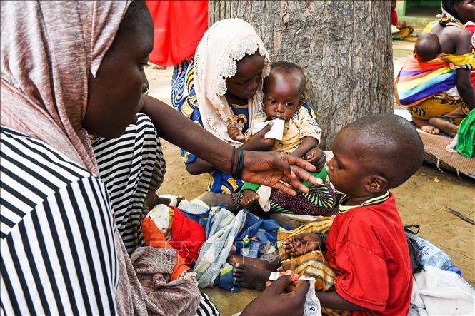 Người mẹ đút cho em nhỏ ăn tại trung tâm y tế ở Makary thuộc Cameroon. Ảnh: THX/TTXVN